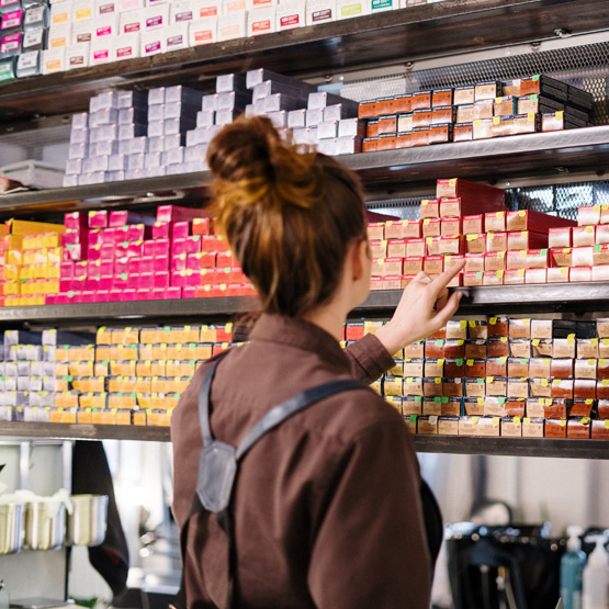 Person choosing item from shelf at Alan Howard store