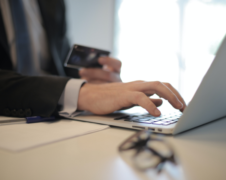 person holding credit card by ecommerce site on screen