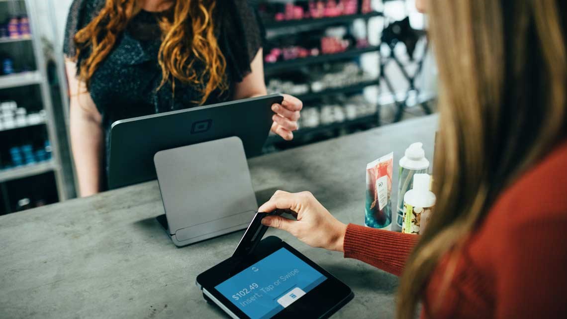 woman paying for items with card in store