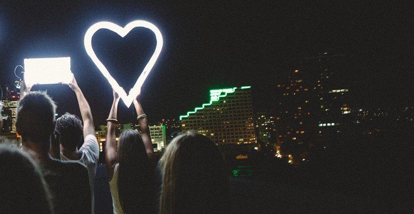 Woman holding glowing heart shape