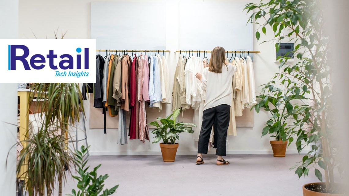 Woman browsing rail of clothes