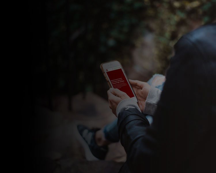 Person holding mobile phone showing Red Technology website