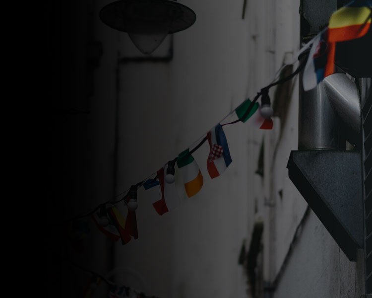 different international flags hanging between buildings